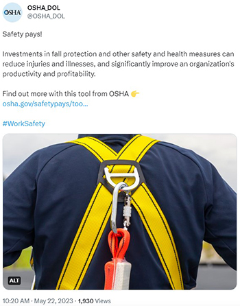 A worker wearing a fall protection harness with a carabiner.